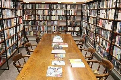 The image shows the Mechanics Institute Library with a large table in the middle with seating.