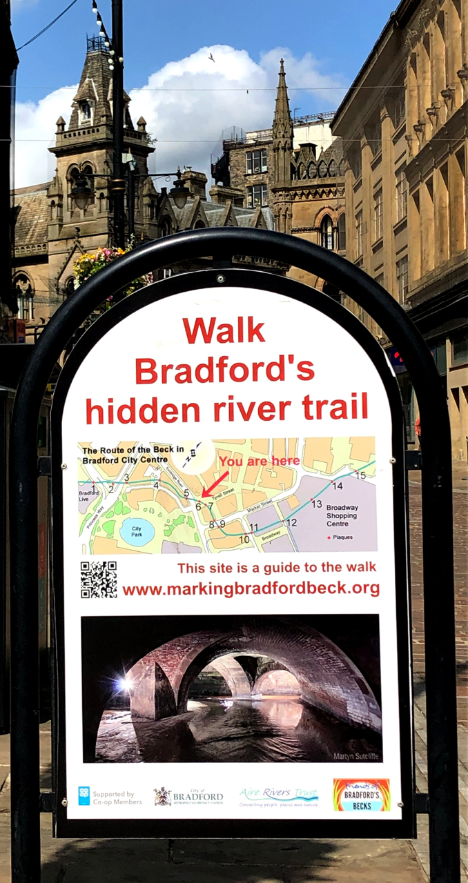 A-board with red text saying "Walk Bradford's hidden river trail