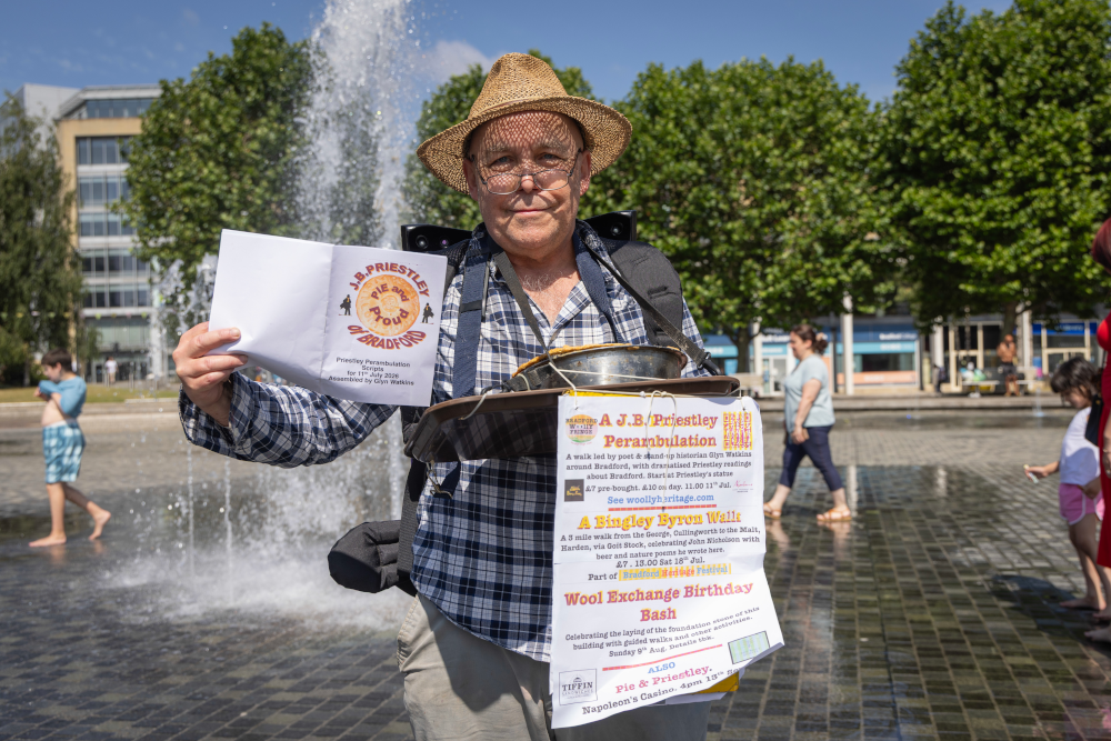 A man holding up a leaflet and poster